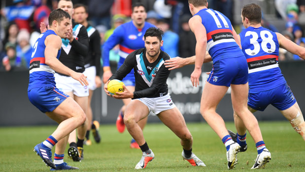 Evasive action: Chad Wingard looks for a way through the pack of Bulldogs.