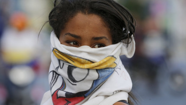 An anti-government protester takes part in a road block in Caracas, Venezuela.