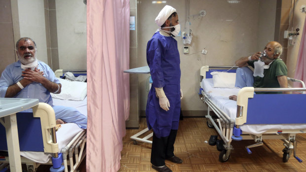 A cleric talks with a patient infected with coronavirus, at a hospital in Qom, 125 kilometres south of the capital Tehran, Iran. 