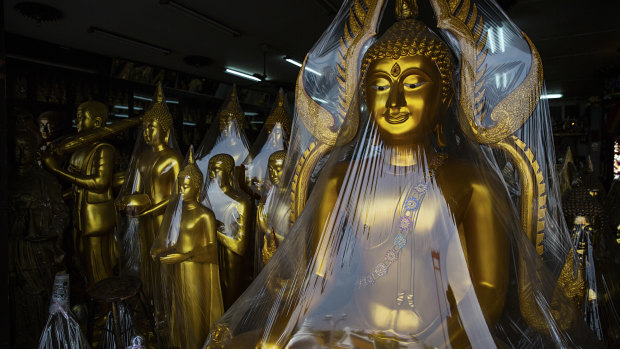 A Buddha statue and trinket shop in Bangkok, Thailand.