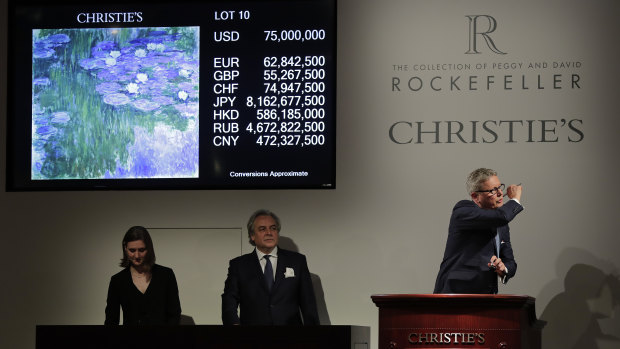 Global president of Christie's, Jussi Pylkkanen, right, taps the gavel on the podium for the final sale at $75 million of Claude Monet's "Nympheas en fleur" during an auction from the collection of Peggy and David Rockefeller on May 8.