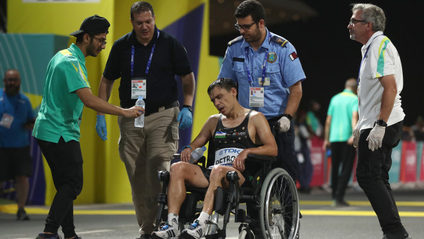 Andrey Petrov of Uzbekistan is taken away in a wheelchair after the men's marathon at Doha.