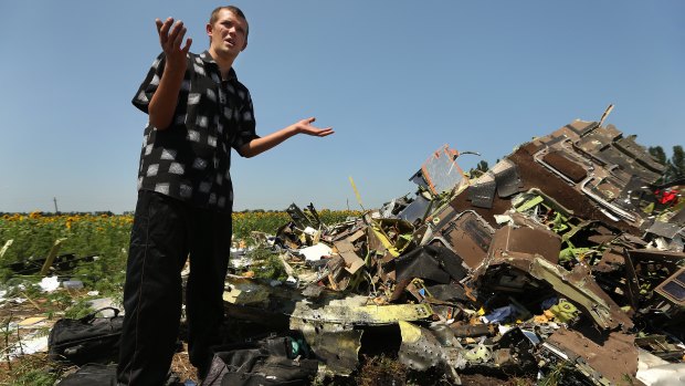 Donetsk People's Republic sniper Eugene Lukovkin stands among pilots' bags where he witnessed the front section of MH17 crashing and found the pilots bodies.