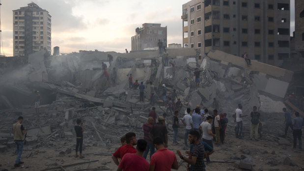 Palestinians inspect the damaged Said al-Mishal cultural centre after it was bombed by an Israeli airstrike in Gaza City on August 9.