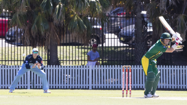 On-field reunion: Steve Smith looks on in slips as David Warner lets one go at Coogee Oval.