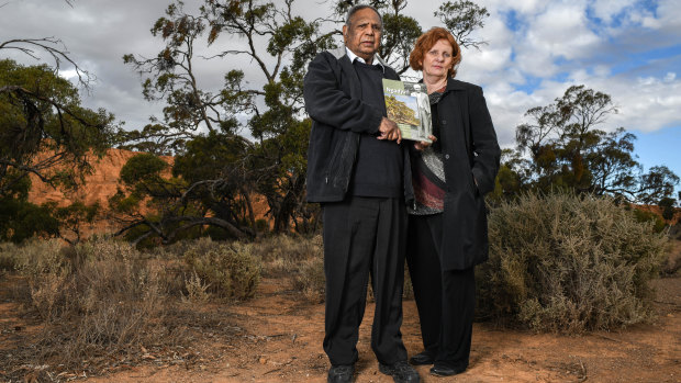 Vince Copley and Professor Claire Smith of Flinders University at Red Banks Conservation Park in Burra, SA, with a book on the Ngadjuri featuring Copley's grandfather, Barney Waria, on the cover. 