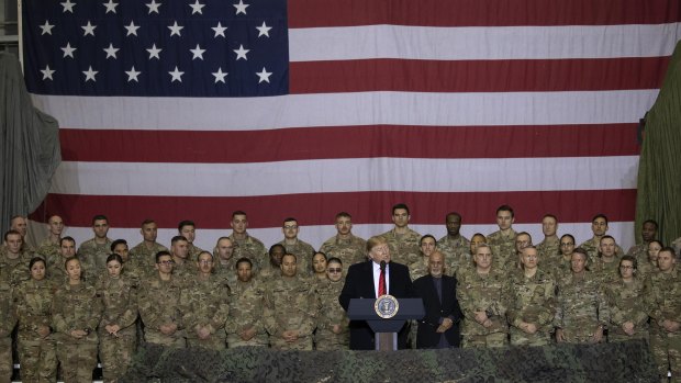 US President Donald Trump addresses members of the military during a surprise Thanksgiving Day visit last month.