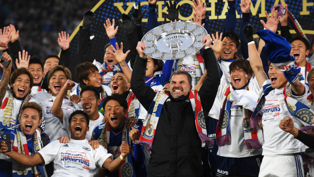 Ange Postecoglou raises the J-League trophy in triumph in Yokohama.
