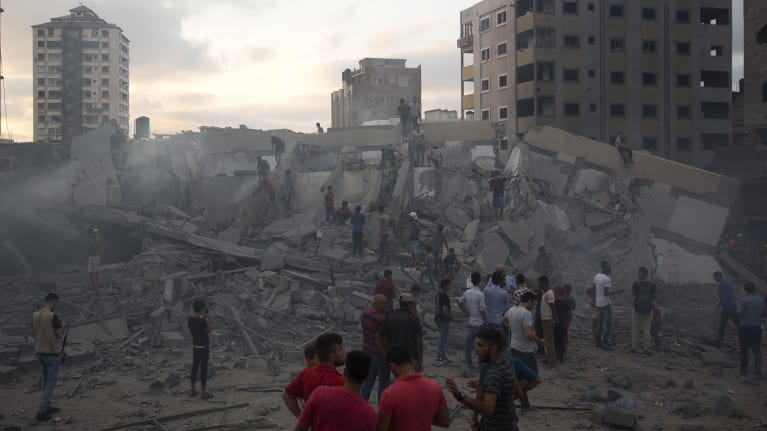 Palestinians inspect the damaged Said al-Mishal cultural centre after it was hit bombed by an Israeli airstrike in Gaza City on August 9.