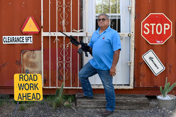 Richard Small poses for a portrait with his AR-15 before turning it over to police.