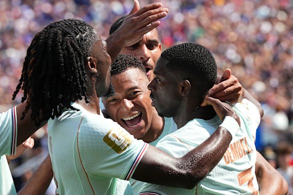 France’s Ousmane Dembele, right, celebrates with Kylian Mbappe, center, and other teammates after scoring his side’s third goal.