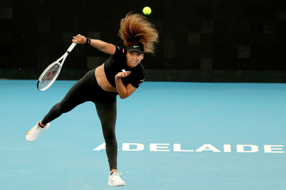 Naomi Osaka serves against Serena Williams in their Adelaide practice match.