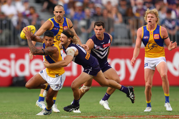 Tim Kelly of the Eagles looks to break from a tackle by James Aish.