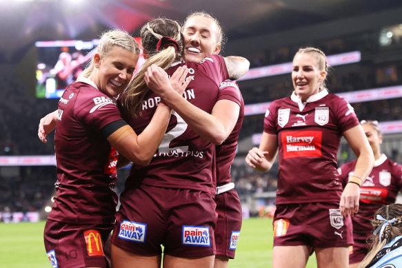 Queensland players celebrate Julia Robinson’s opening try during game one.