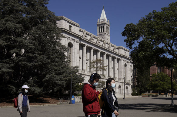 People walk past Wheeler Hall on the University of California campus in Berkeley, California.