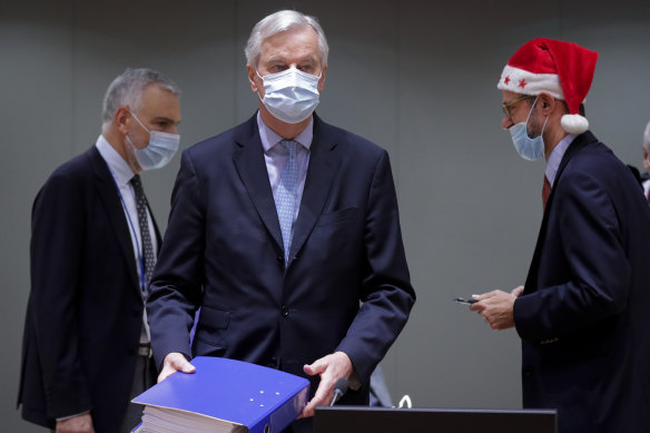 European Union chief negotiator Michel Barnier, center, brought a 1000-page copy of the Brexit trade deal to a Christmas Day meeting in Brussels. 