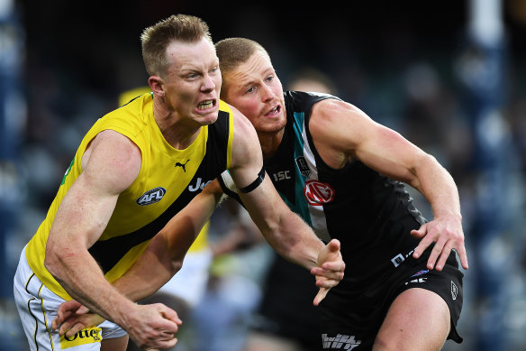 Richmond's Jack Riewoldt, left, and Port Adelaide's Tom Clurey, right, grimace in the hard-fought contest.