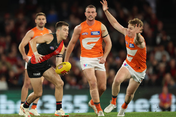 Zach Merrett of the Bombers runs with the ball.