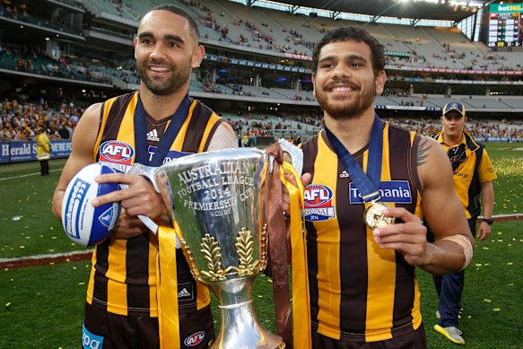 Shaun Burgoyne and Cyril Rioli celebrate the 2014 premiership win by Hawthorn.