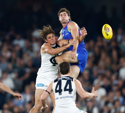 Kallan Dawson of the Kangaroos and Charlie Curnow of the Blues compete for the ball.