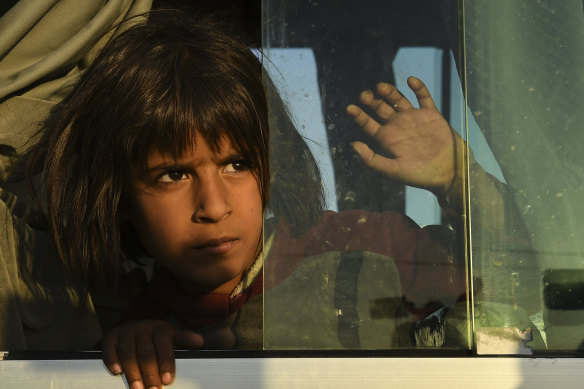 A young Syrian girl peers out the window of one of the buses bring 784 Syrian refugees to Bardarash Refugee Camp in Iraqi Kurdistan.