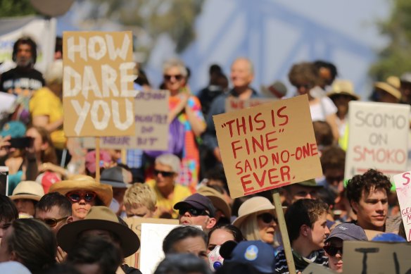 Protesters holding placards demand climate action outside Kirribilli House in Sydney on Thursday.