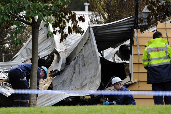 Police forensics and arson and explosives squad members sift through the remains of the house fire in Zig Zag Road in 2010.