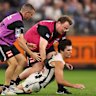 Lachie Schultz of the Magpies collapses in the hands of medical staff.