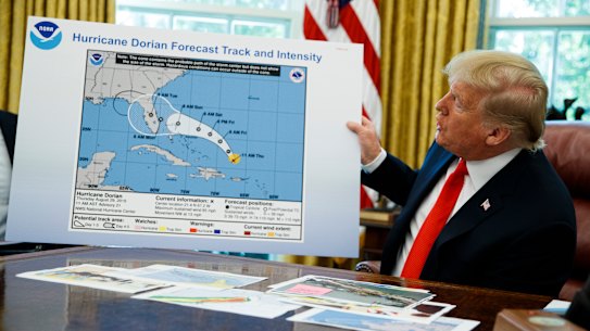 President Donald Trump holds the chart with the extended impact zone of Hurricane Dorian in the Oval Office in September.