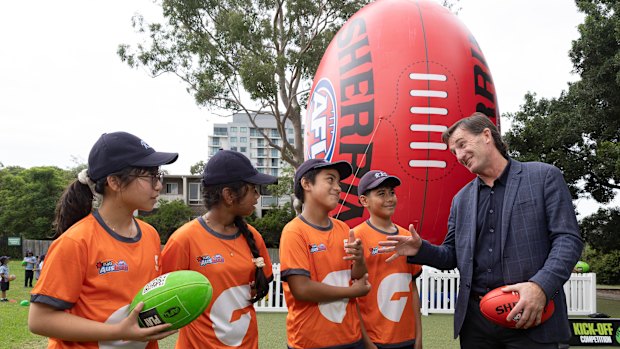 AFL CEO Andrew Dillon speaks to school children as he poses with students from Rosehill Public School during an AFL School Connect visit to Rosehill Public School as part of the build-up to opening round.