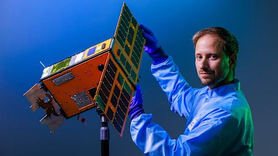 Melbourne University electronic engineer Miguel Ortiz del Castillo with a scale model of the SpIRIT nano satellite.