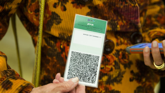 An Israeli woman presents a COVID-19 vaccination certificate - or Green Pass - before entering a musical performance at Tel Aviv’s concert hall.