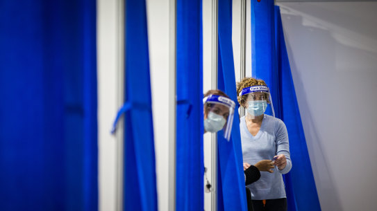 Staff at a mass vaccination centre at the Melbourne Exhibition Centre .