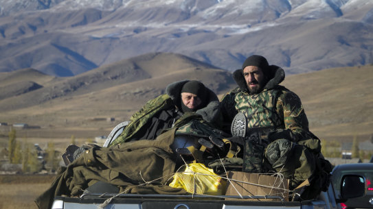 Ethnic Armenian soldiers ride a car passing the border between Nagorno-Karabakh and Armenia near Vardenis on Sunday.