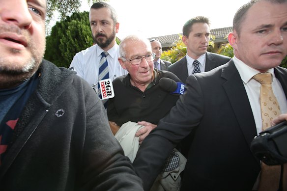 Detectives surround Roger Rogerson outside his Padstow Heights home in May 2014. 
