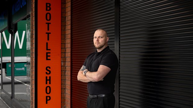 Chris Thompson outside his bottle shop in Oakleigh that will have to take down its roller shutter soon.