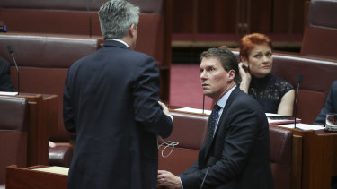 Finance Minister Mathias Cormann in discussion with Cory Bernardi and Pauline Hanson during a division in the Senate on the last sitting day of 2018. Both filibustered on the government's behalf.