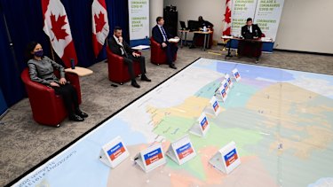 Chief Public Health Officer Dr Theresa Tam, left, and Major-General Dany Fortin, second from left, join other members of the vaccine distribution task force during a rehearsal of a concept drill for the COVID-19 vaccine rollout in Ottawa. 