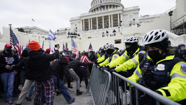 Trump supporters try to break through a police barrier outside the US Capitol in Washington DC.