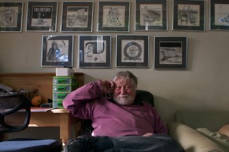 Ron Cobb, at home in Rozelle, Sydney, in 2012. Some of his 1960s cartoons are on the wall behind him.