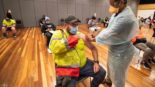 Warehouse worker Daniel Matcham rolls up his sleeve to get jabbed at a clinic in Hoppers Crossing.