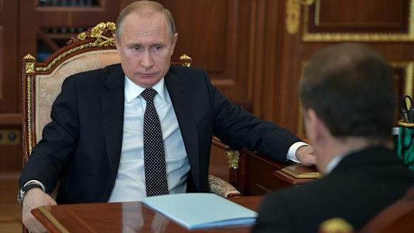 Russian President Vladimir Putin, left, listens to Russian Prime Minister Dmitry Medvedev, back to a camera, during their meeting in Moscow, Russia. 
