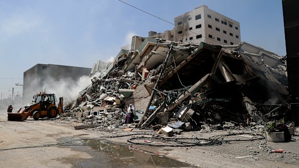 Workers clear the rubble of a building that was destroyed by an Israeli airstrike on Saturday, that housed The Associated Press, broadcaster Al-Jazeera and other media outlets, in Gaza City.