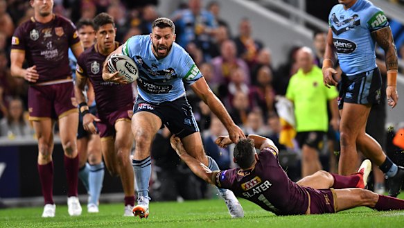 Steamroller: James Tedesco runs over the top of Queensland captain Billy Slater. 
