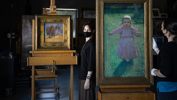 Young Girl by Iso Rae and She Oak and Sunlight by Tom Roberts, on the move with  
Dr. Angela Hesson curator of Australian art and Raye Collins conservator at the NGV.
