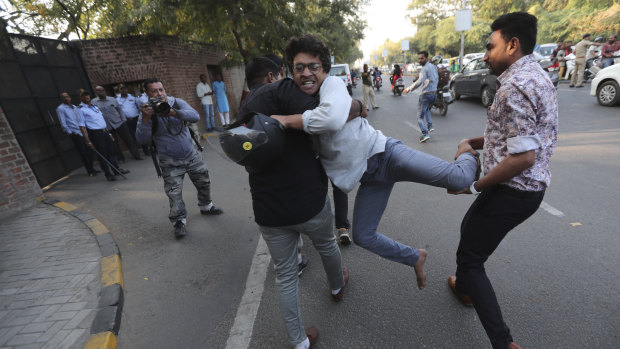 Policemen in plain clothes detain a protester in Ahmadabad.