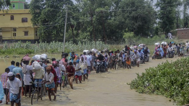 Nepalese people walk through flood waters in Gaur, Rautahat district, Nepal.