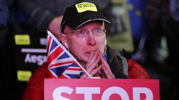 An anti-Brexit demonstrator cries as he gathers in Parliament Square in London.