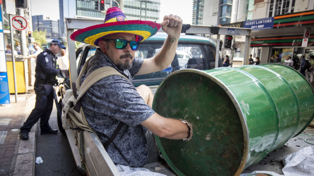 An Extinction Rebellion protester with his arm stuck in a heavy barrel at the intersection of George and Ann streets.