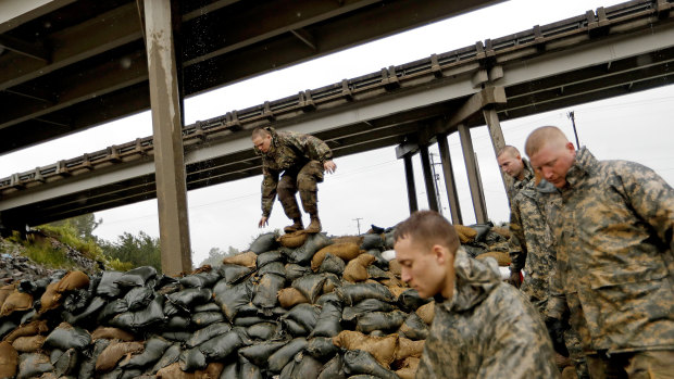 Members of the North Carolina National Guard finish stacking sand bags under a highway overpass near the Lumber River which is expected to flood from hurricane Florence's rain.